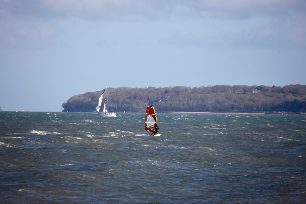 Sailboarder, yacht and Isle of Wight