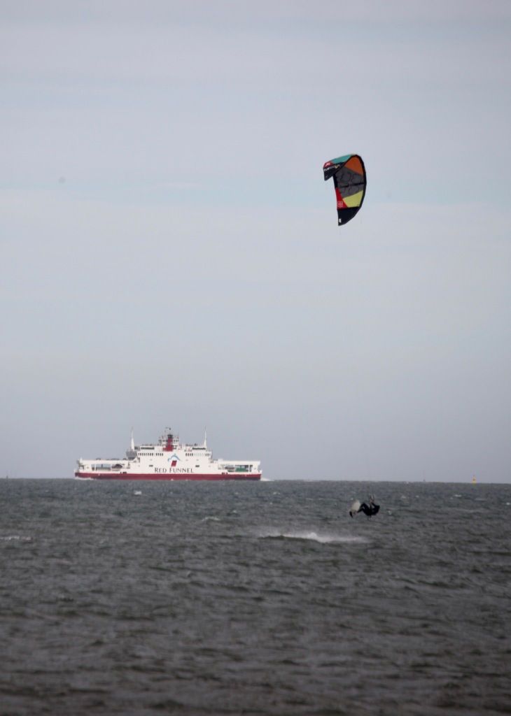 Wind surfer in air and Red Funnel ferry boat